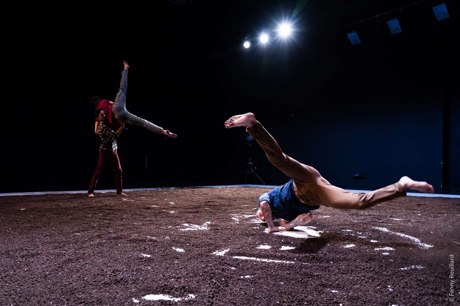 Deux hommes font du breakdance sur un sol sablonneux