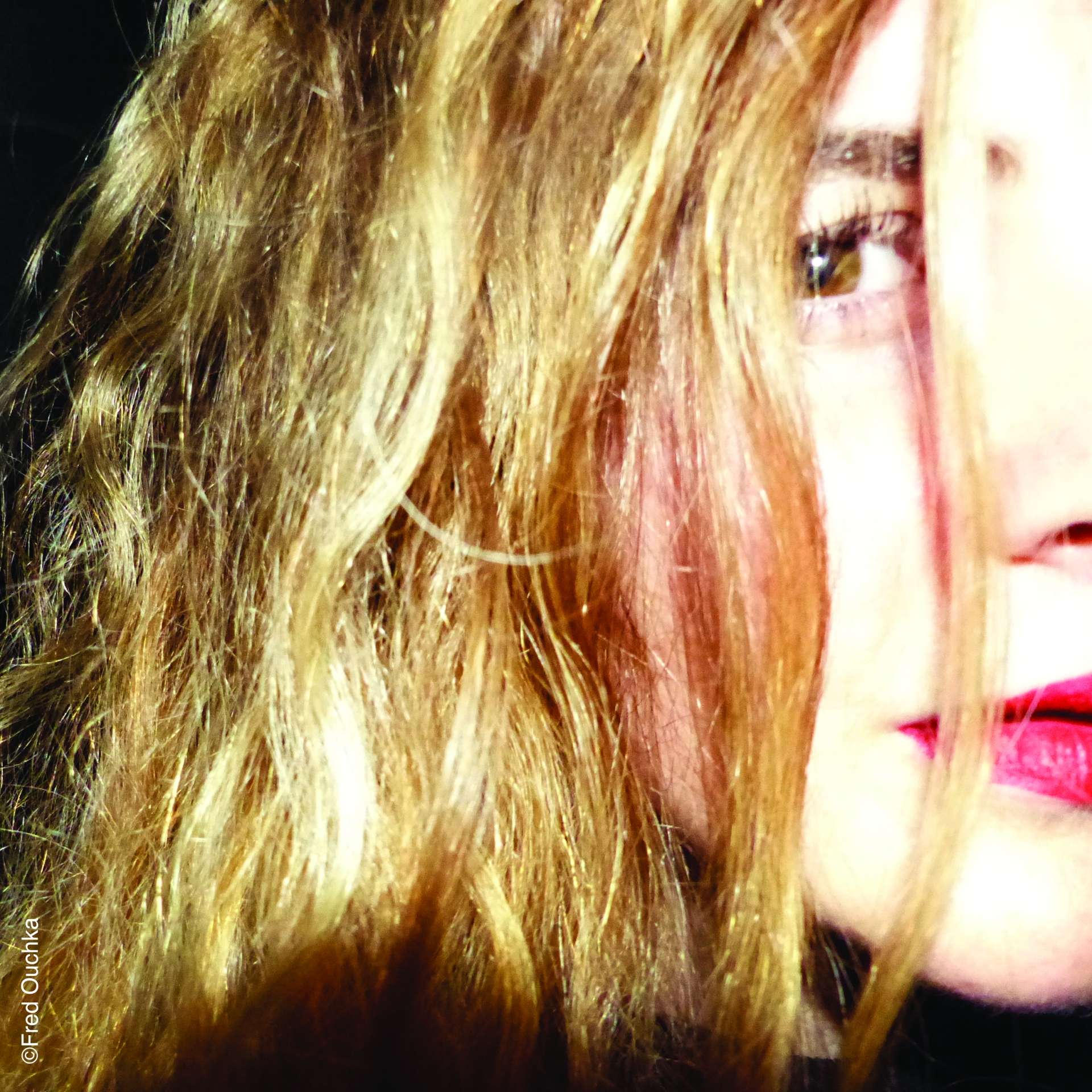 On voit le visage d'une femme blonde dans la lumière.